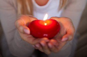 mujer caucásica sosteniendo una vela romántica de san valentín color rojo diy